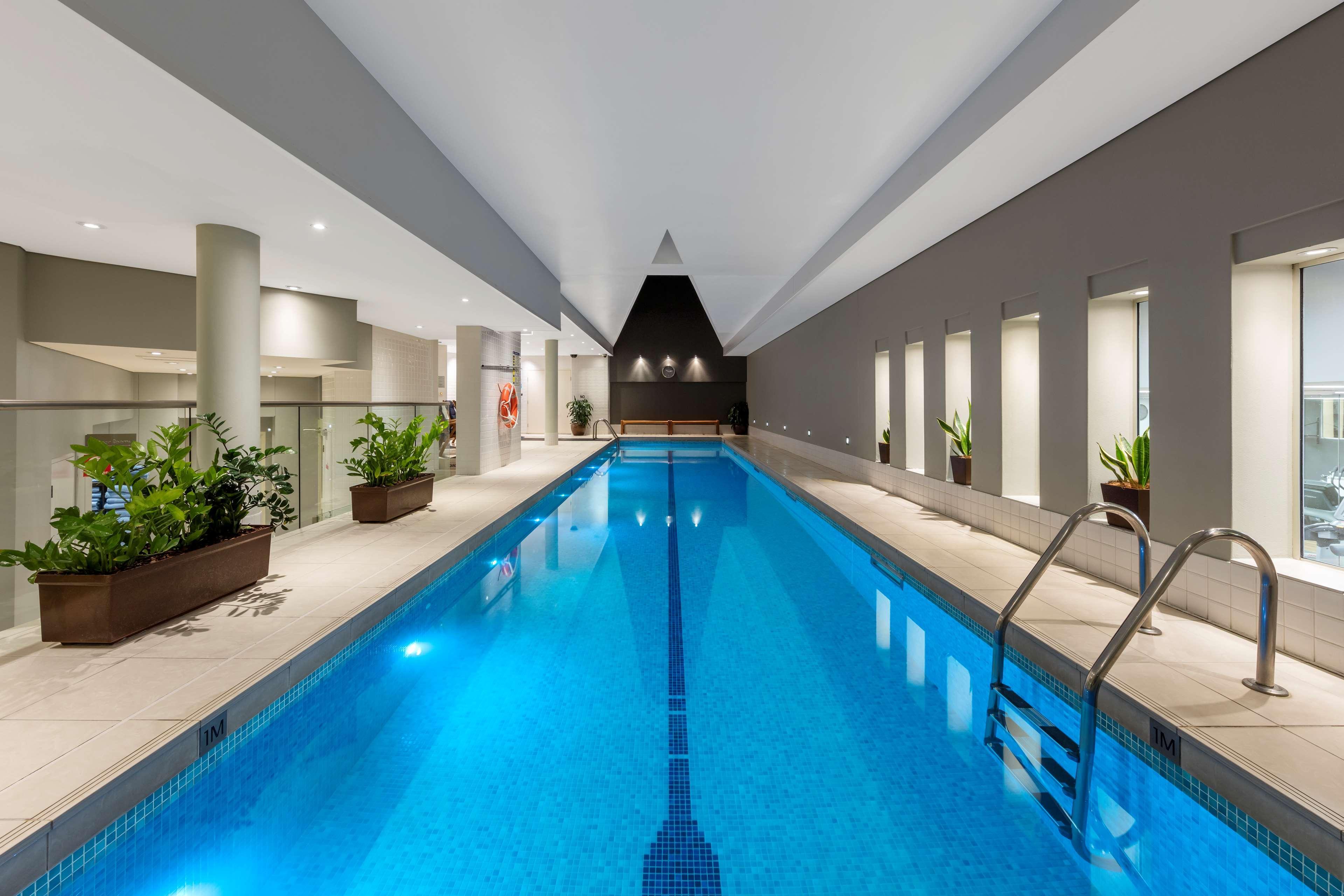 Radisson Blu Plaza Hotel Σίδνεϊ Εξωτερικό φωτογραφία The photo depicts an indoor swimming pool. The pool is rectangular and features a clean, bright blue surface, with steps leading into it. Surrounding the pool are modern architectural elements, including tall, light-colored walls and a ceiling with a