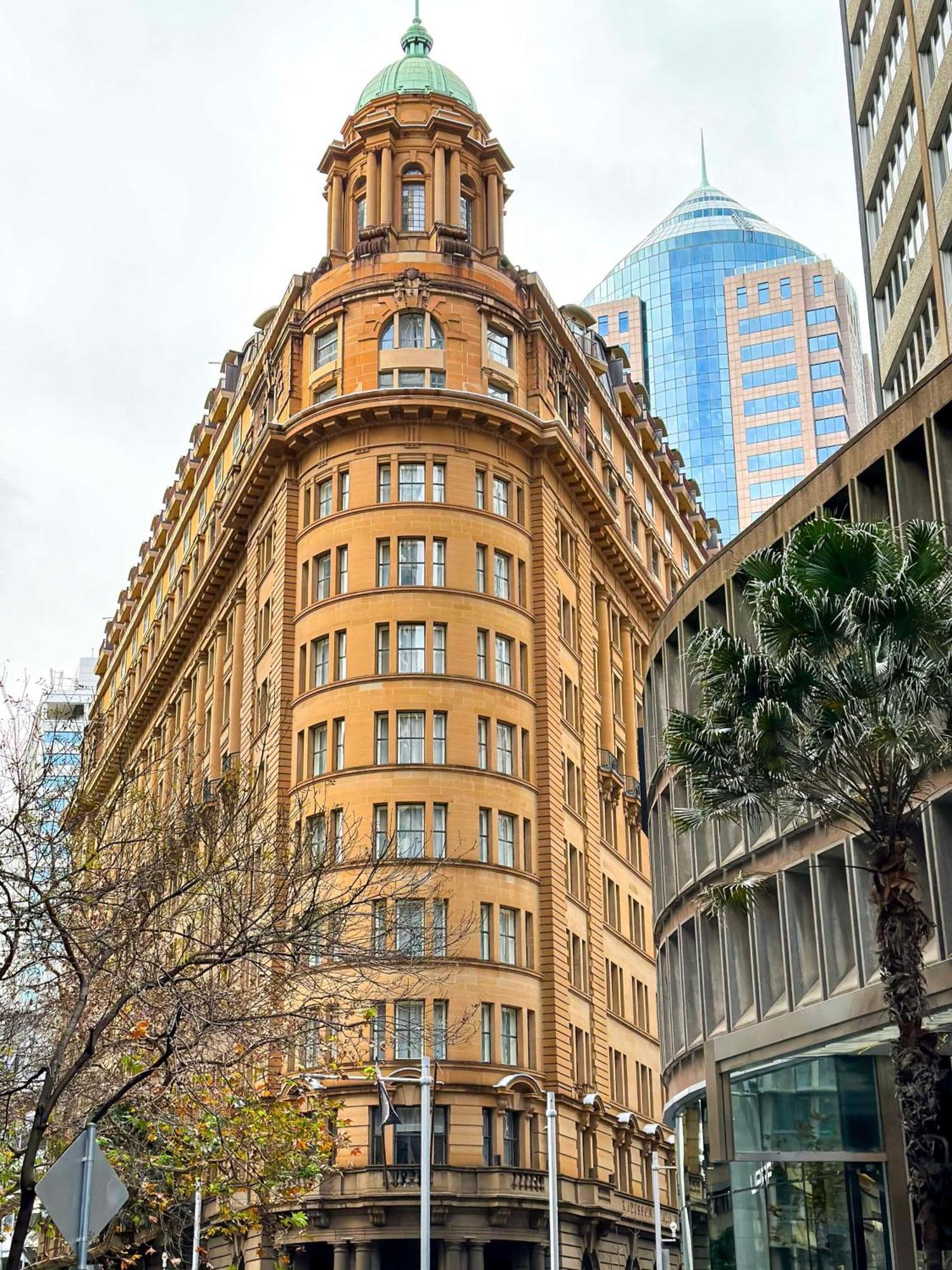 Radisson Blu Plaza Hotel Σίδνεϊ Εξωτερικό φωτογραφία The photo shows a distinctive architectural building with a rounded facade, featuring a tan-colored exterior and multiple windows. This building is likely situated in an urban environment, surrounded by modern skyscrapers, indicated by the glass and 